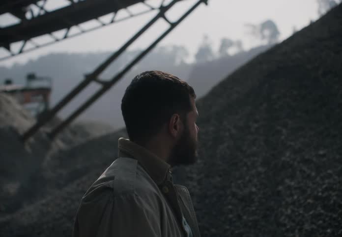 A man stands at a gravel pit and looks around