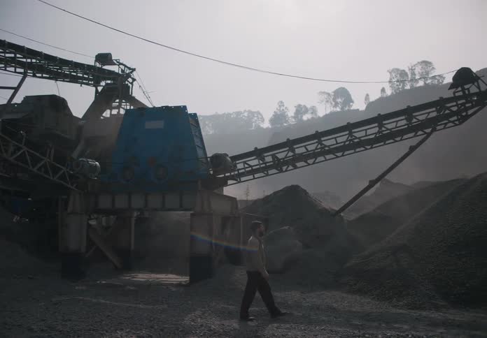 A man looks around as he walks through a gravel pit