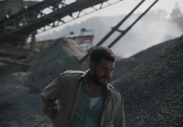 A man is standing in the middle of a stone quarry
