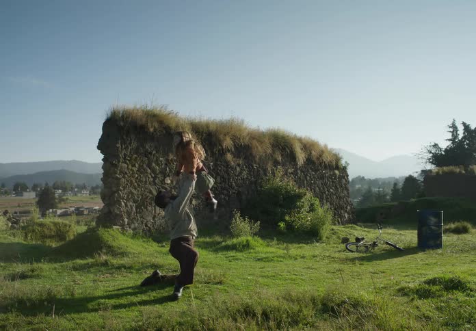 Father and daughter playing near an abandoned rock wall on the countryside at morning