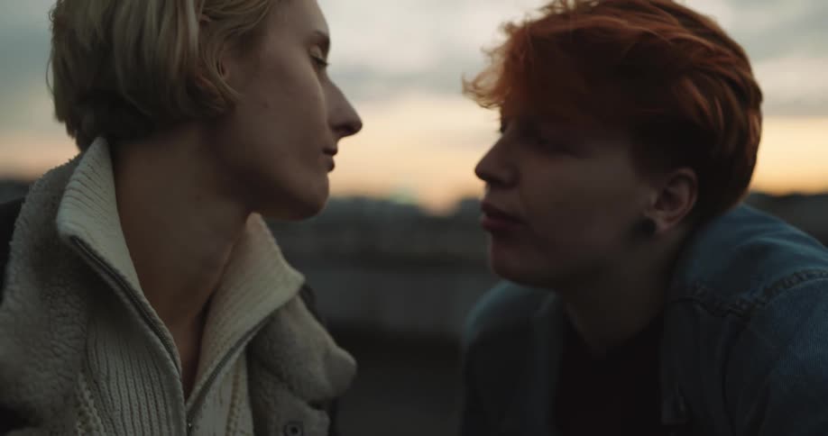 A young couple is outdoors and is kissing
