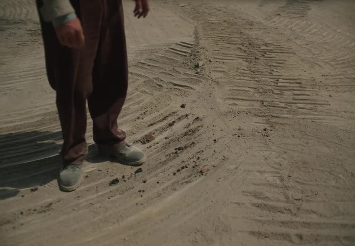 A man is walking around in the sand