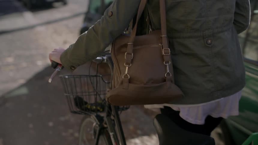 A person pushes their bike down the sidewalk