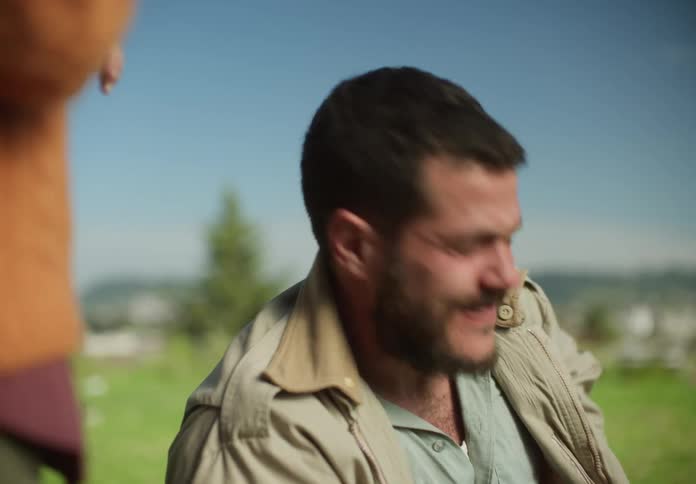 A man reaches in his jacket pocket and pulls out a firecracker and a red lighter and he lights the firecracker and throws it then hugs his young daughter who is watching him