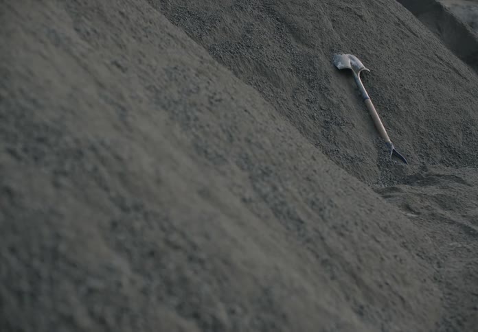 Gravel falls over a shovel on a mound