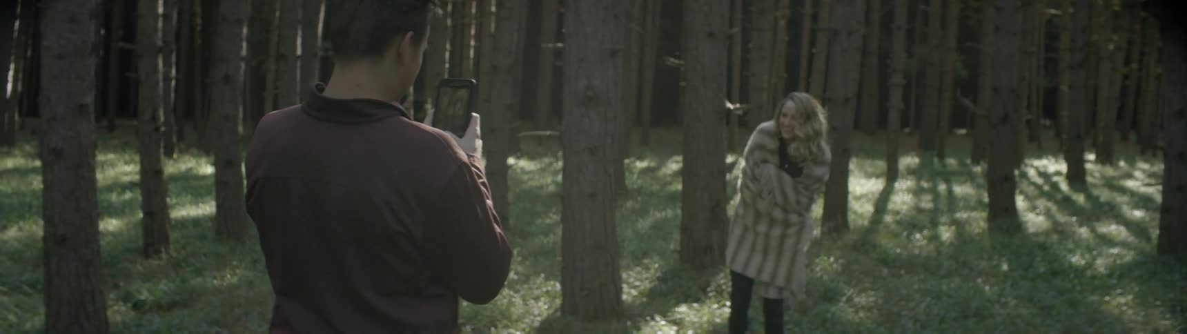 A girl poses for a picture in the woods