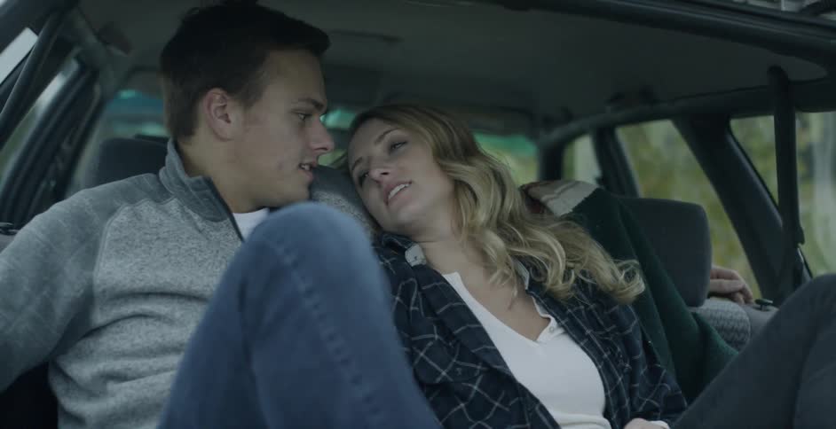 A man and woman sit together in a car