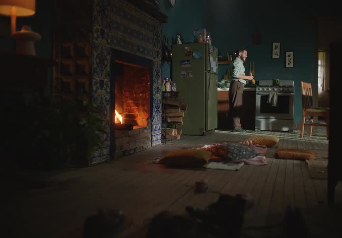 A father and daughter are inside of there home and are walking by the fire place