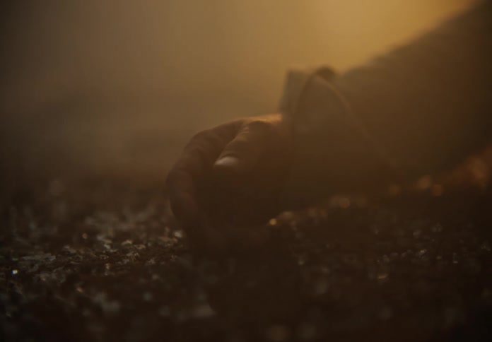 An arm laying on the ground in a smoke filled area