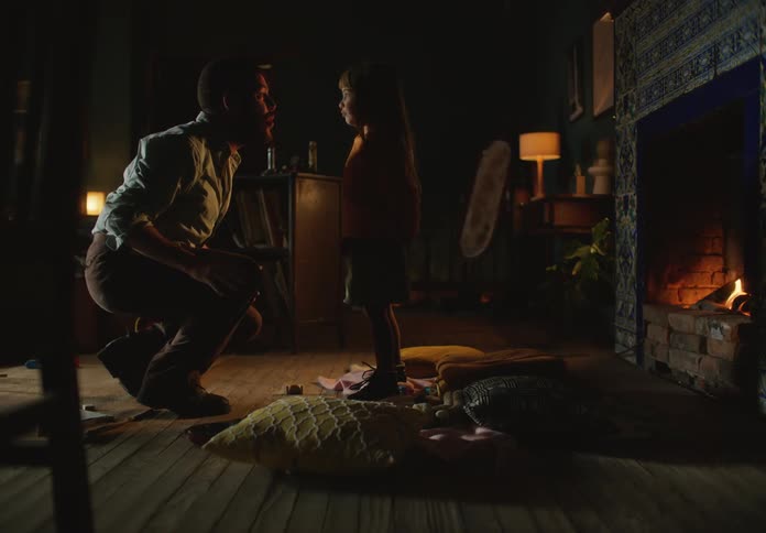 Father and daughter playing in the living room in front of the fireplace