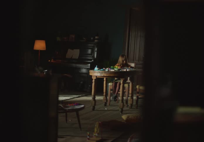 Girl sitting at dining table near piano colors