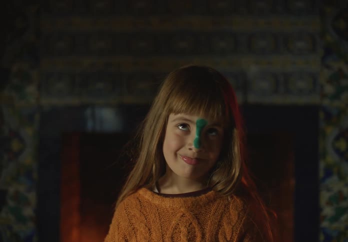 There is a kid indoors that is playing around in front of a fire place