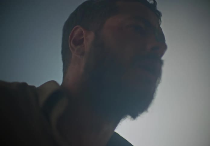 Man with a confused look stumbles around a room filled with smoke