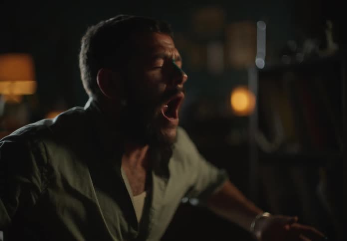 Man with blue colored nose smiles as he howls in home