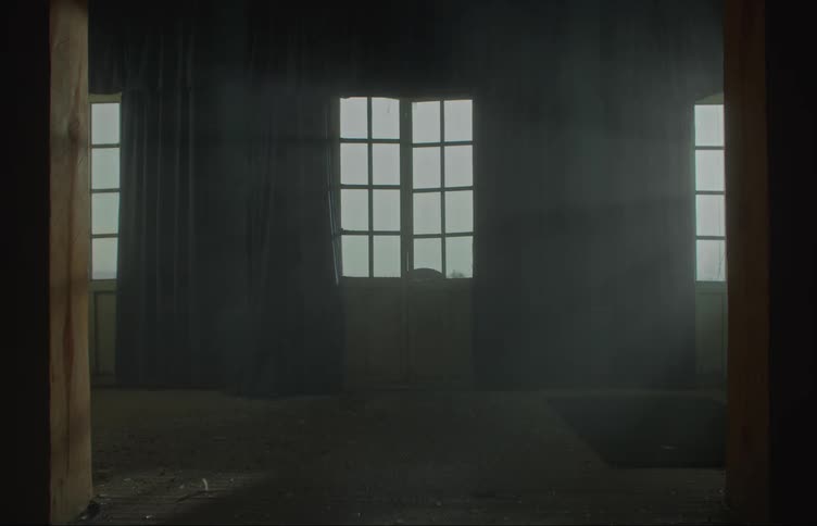 Smokes filling the dimly lit living room of a house