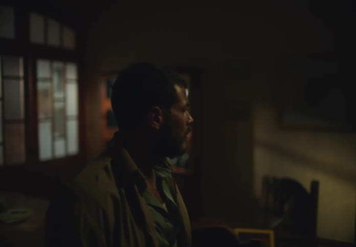 A man walks in to a dark room and looks around