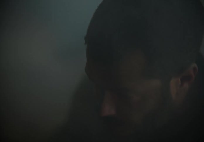 Struggling man breathes deeply in smoke filled area