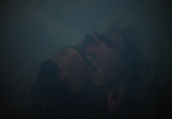 A man lies on the ground passed out in a smoke filled room