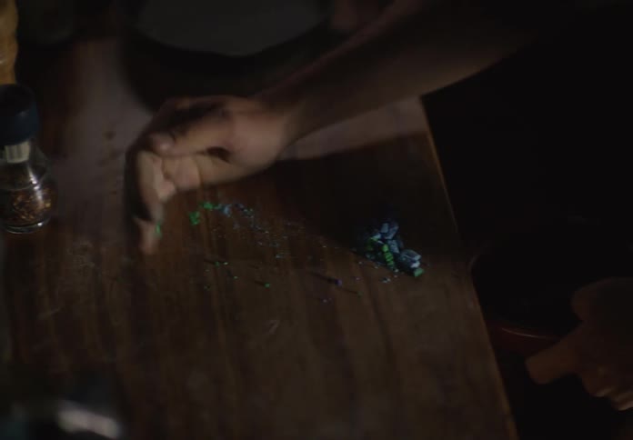A person crushes a few pieces of chalk and mixes the powder with water in a small bowl