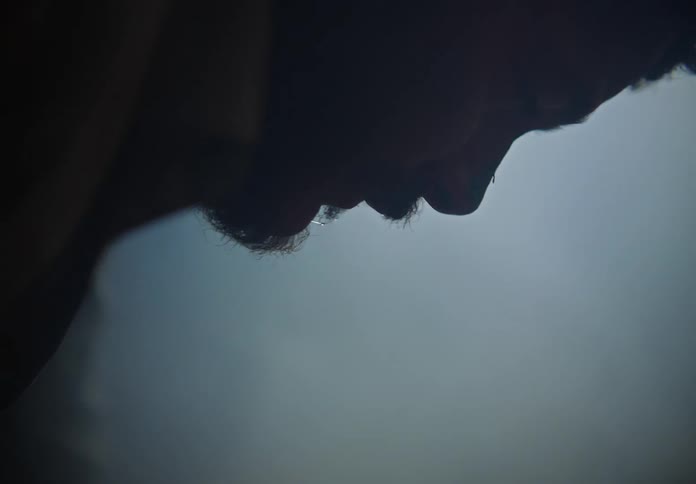 A man leaves over as he spits and shakes
