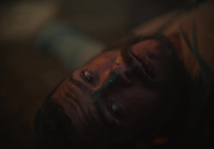 A man looks scared as he lays on the ground