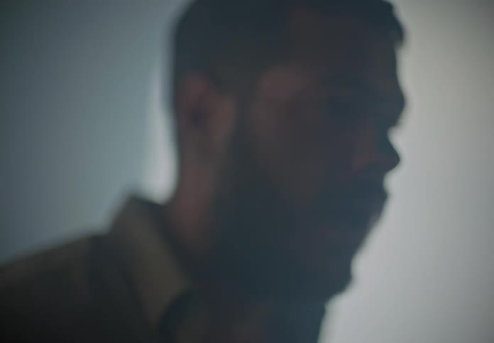 A scared male is stumbling around in a smoke filled area