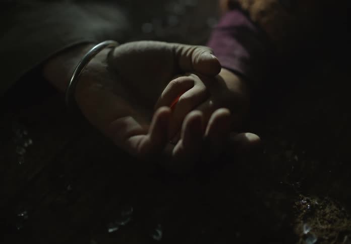 Hand of a toddler delivers a warm bright yellow orb on the hand of a man