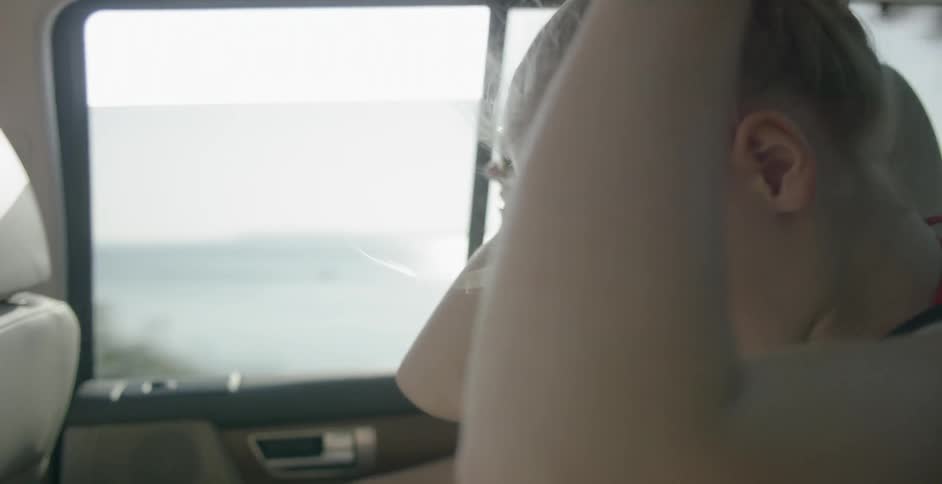 Two young females in the back seat of a moving vehicle