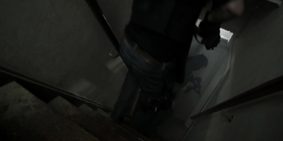 Police descend a dark stairwell with weapons