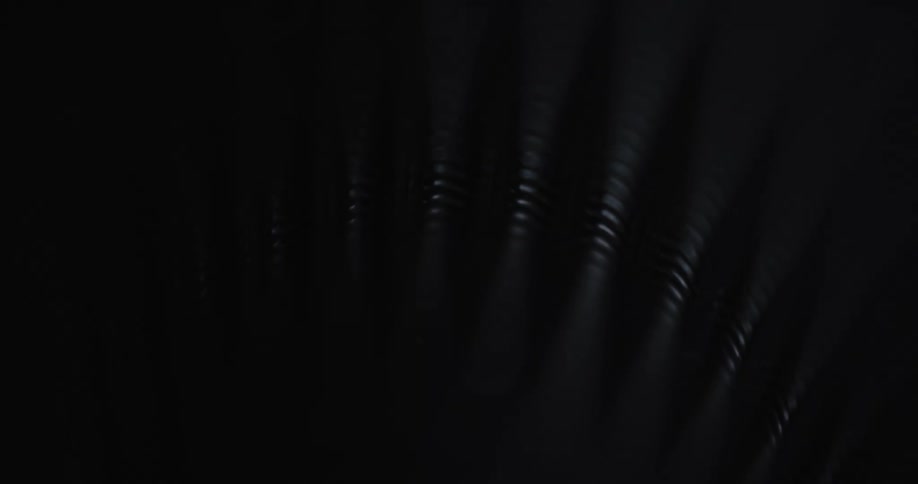 Plastic surface forms series of ribbed areas decorated with thin parallel lines as light brightens and darkens