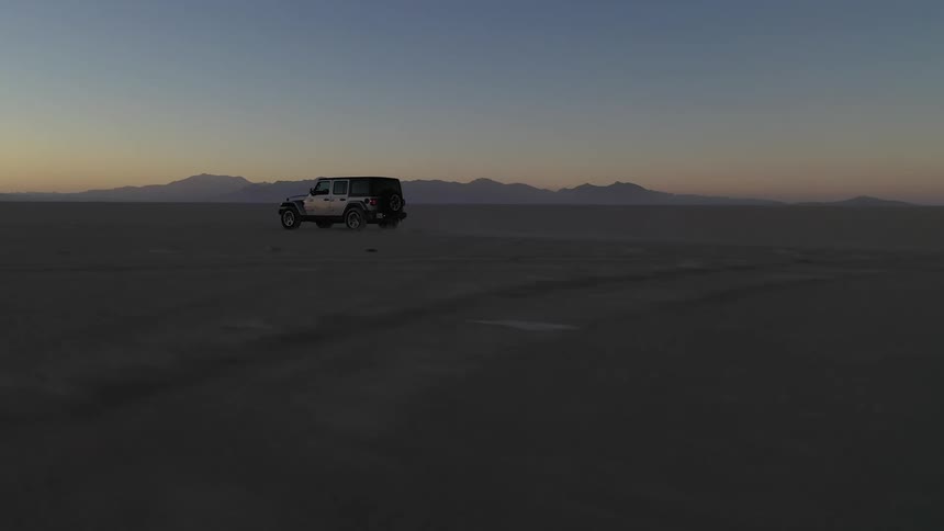 A jeep traveling quickly in the desert