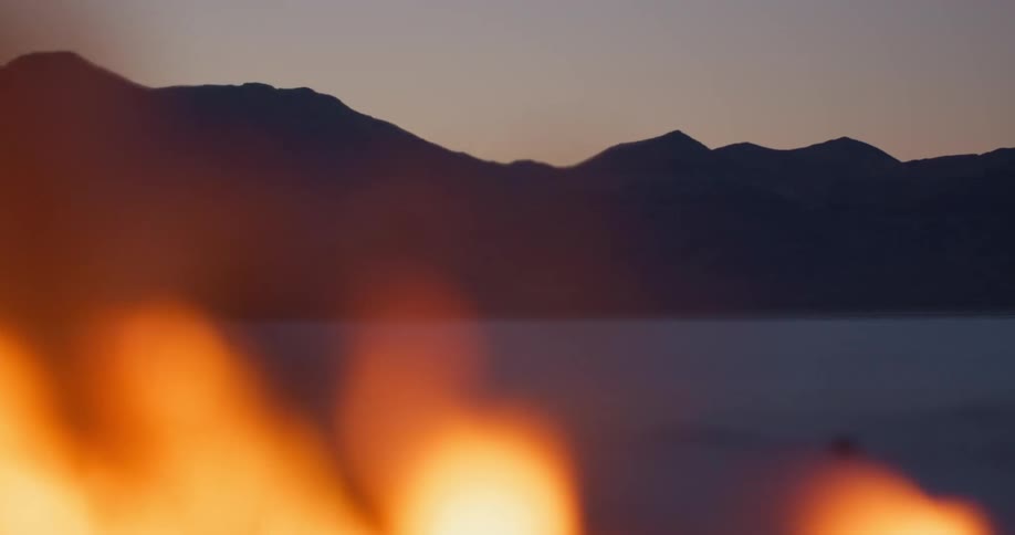 Flames burning in front of a mountain range