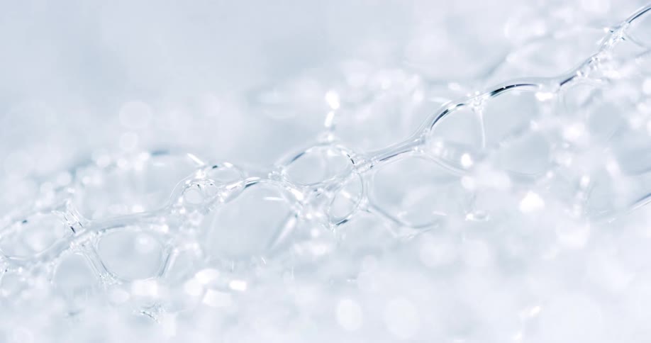 Bubbles form on the surface of a soapy liquid