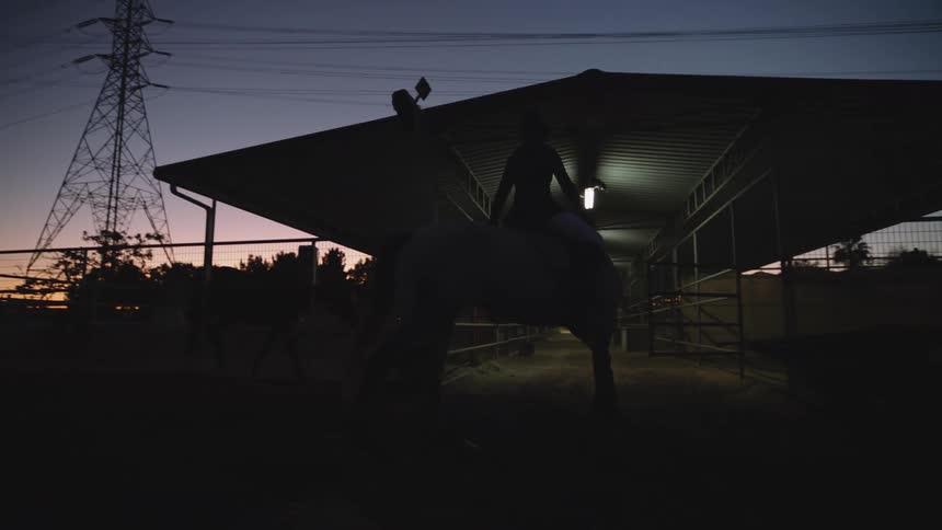 A woman rides her horse on the ranch