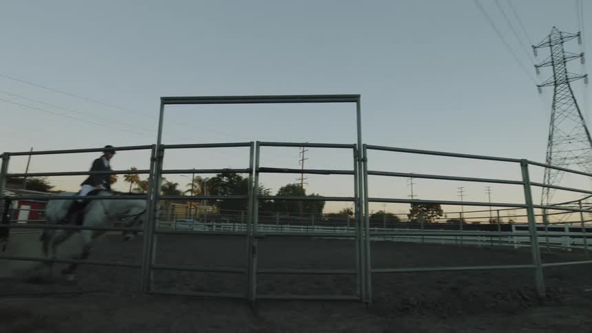 A person riding a horse in a corral
