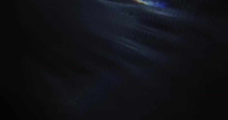 Light shines into darkness revealing white powder textured surface