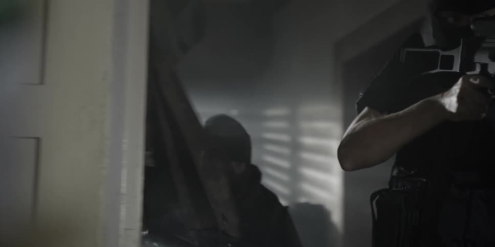 Armed policemen search a house