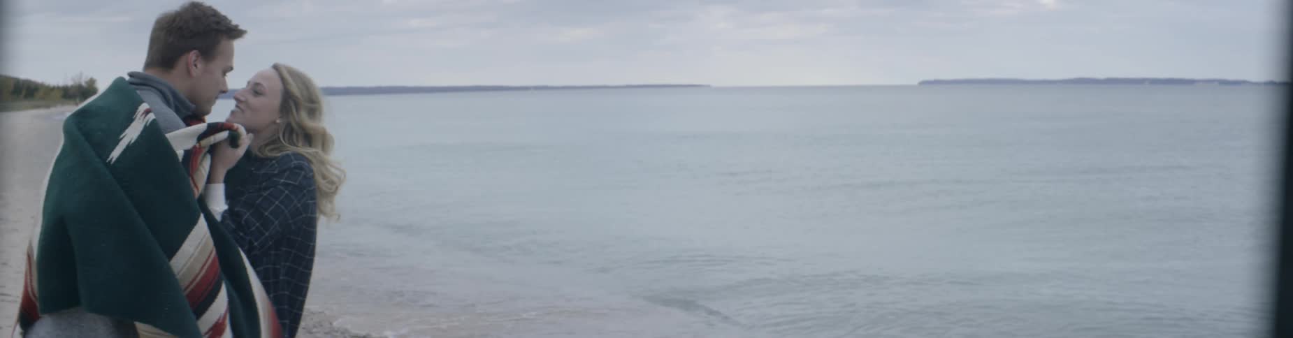 A woman walks from the water with a towel