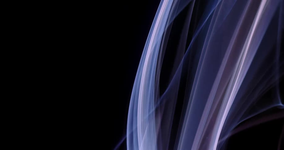 Filmy light colored gaseous layers flow upward contrasting with black background