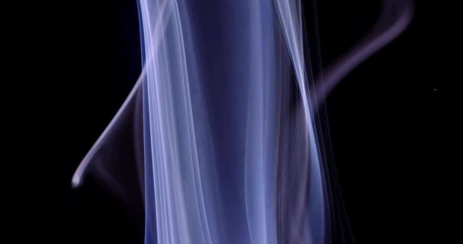 Wisps of lavender smoke bend and sway as they rise in the darkness