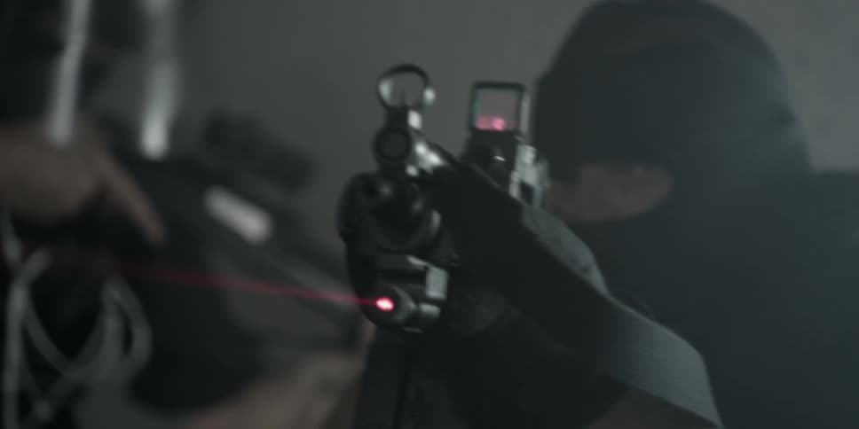 Hooded sniper turning and aiming his weapon
