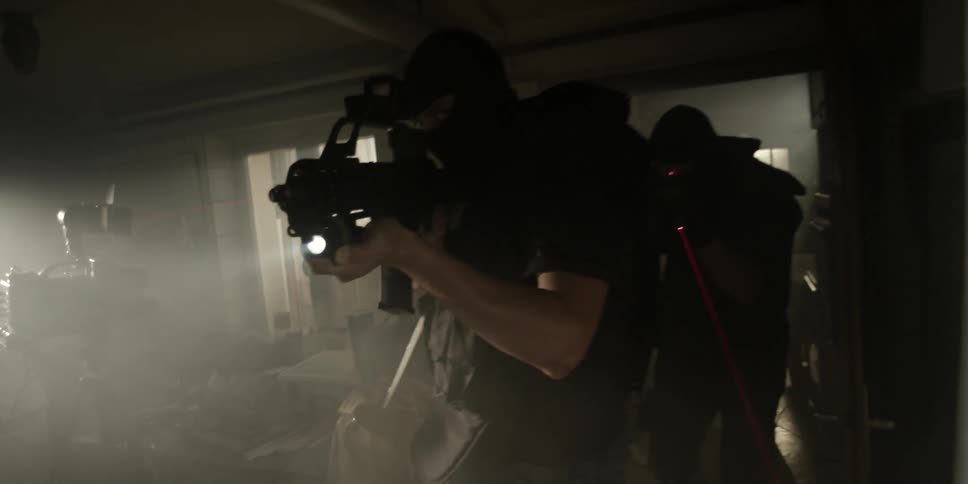 Police searching a house with their weapons drawn