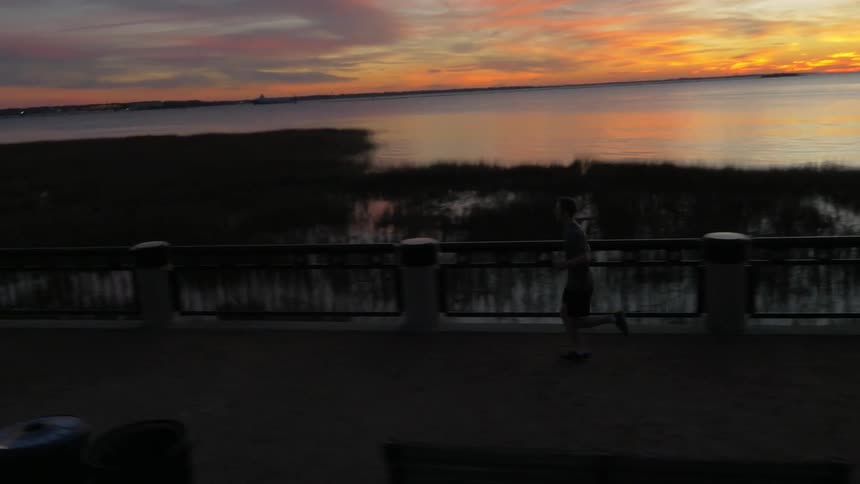 A man jogs at sunset