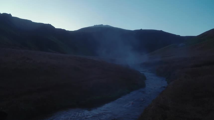 Steam or mist rising from a river in the countryside at morning