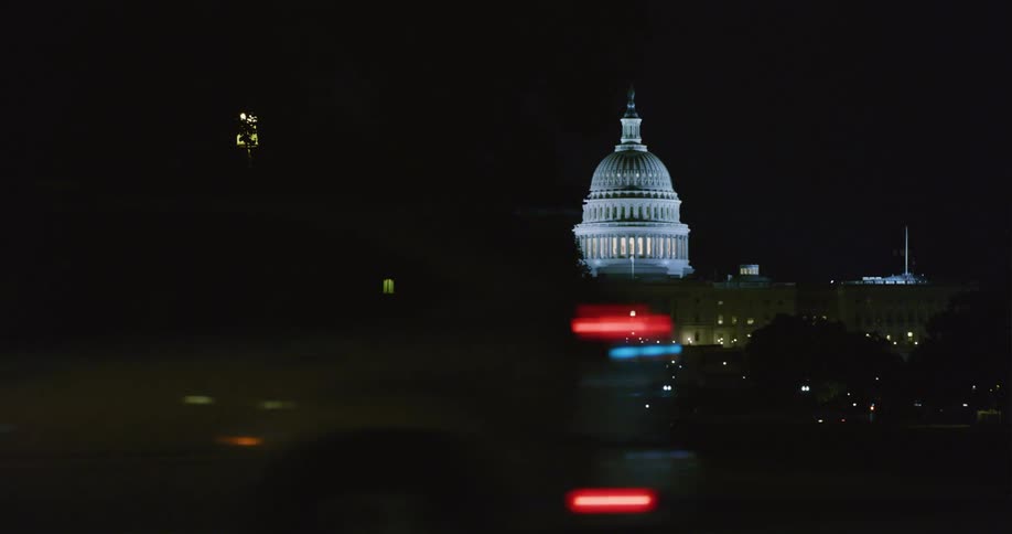 The view is of the downtown area at night time and vehicles are driving