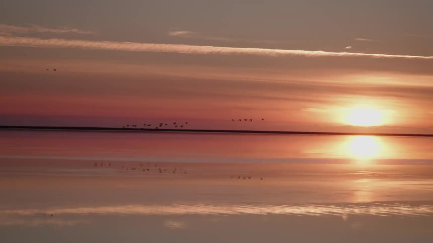 The sun is very low in the sky which causes the clouds to have a beautiful color