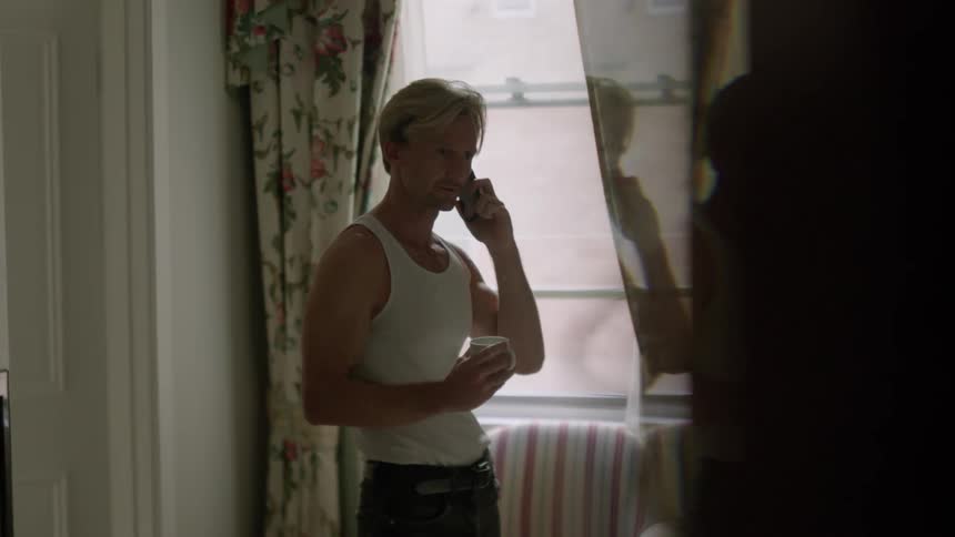 A man is talking on his phone indoors