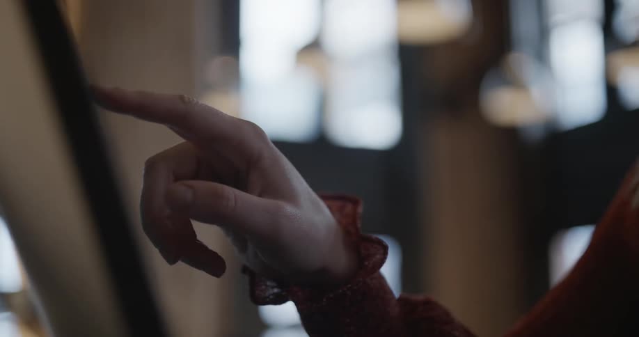 A woman uses her finger to repeatedly tap a touchscreen