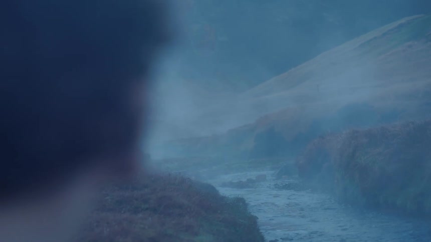Close up of the face of a beautiful woman looking a river surrounded by mist
