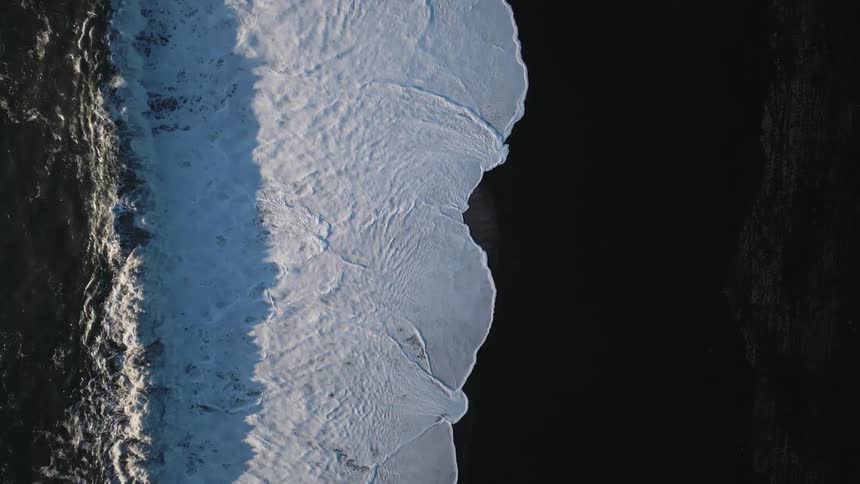 Birds eye view of ocean waves crashing in to the shore